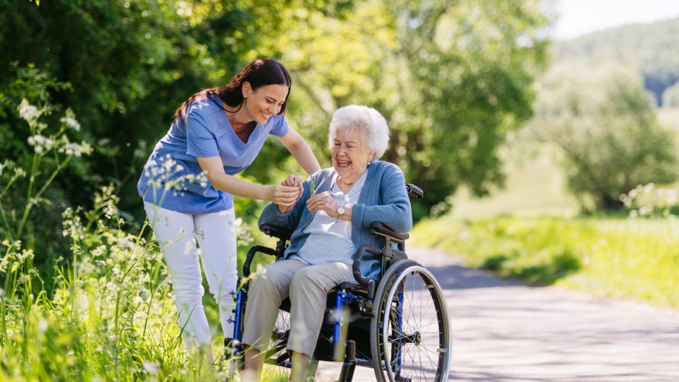 An elderly woman in a wheelchair is accompanied by her assisted living nurse on a nature walk in Guntersville, AL.