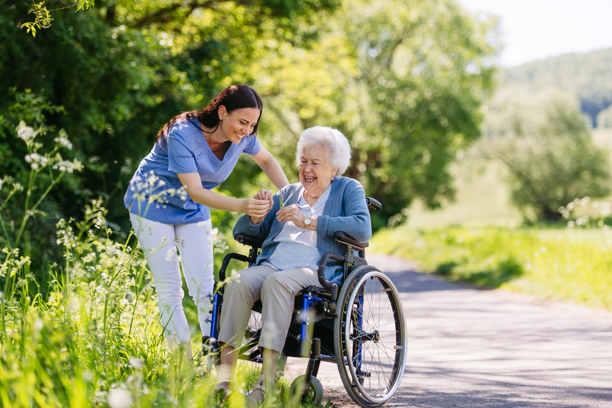 An elderly woman in a wheelchair is accompanied by her assisted living nurse on a nature walk in Guntersville, AL.