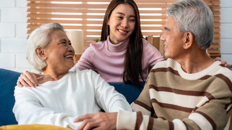 A young granddaughter visits her grandparents in a senior living community, keeping the family involvement in senior care going.