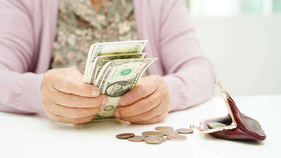 A senior woman gets her wallet out to start counting money she plans to use for her assisted living costs.