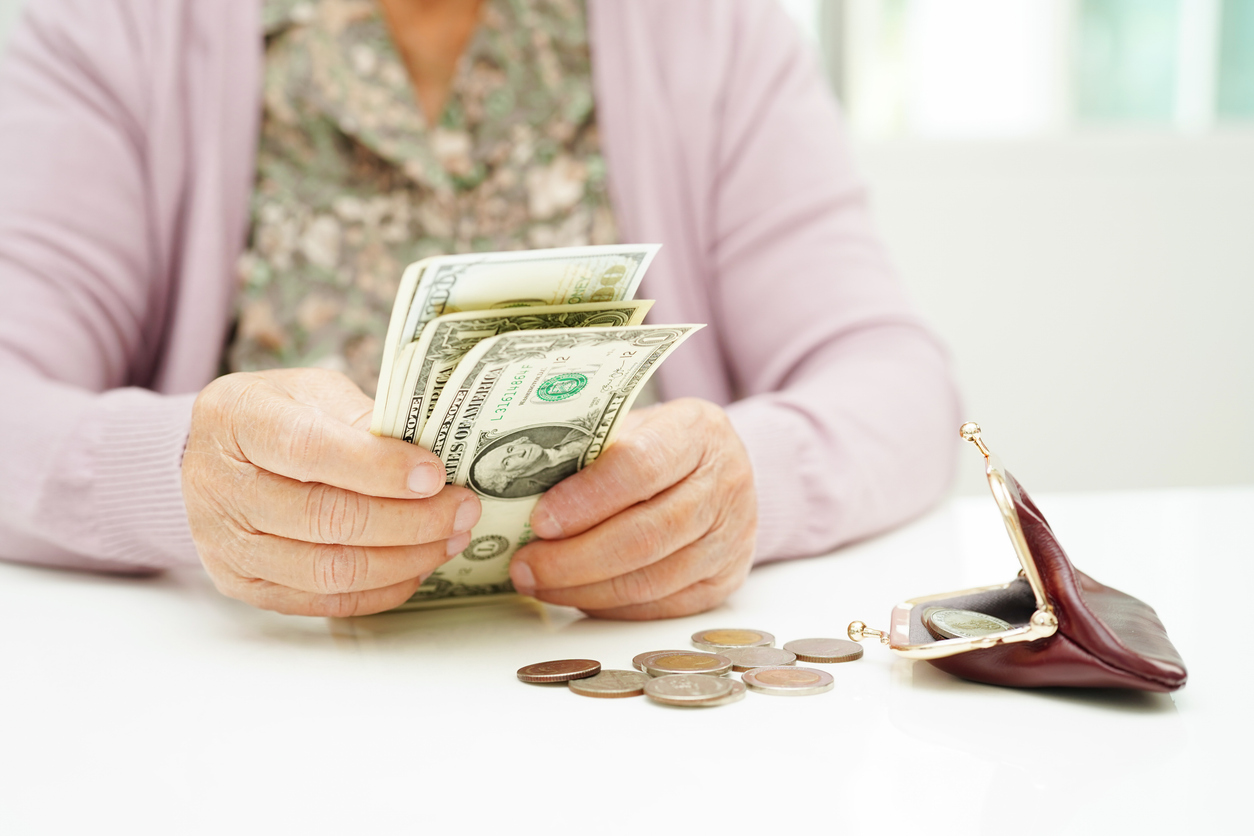 A senior woman gets her wallet out to start counting money she plans to use for her assisted living costs.
